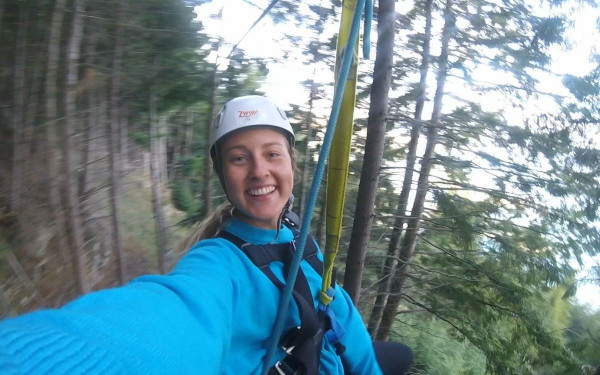 Woman ziplining with go pro in Queenstown, New Zealand